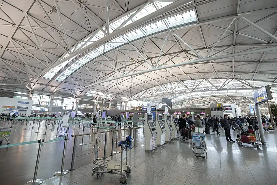 The departures hall of Incheon Airport Terminal 1 under a curved steel roof