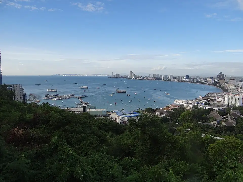 Pattaya Bay seen from a wooded hill, the city and Beach Road along the curve of the shore