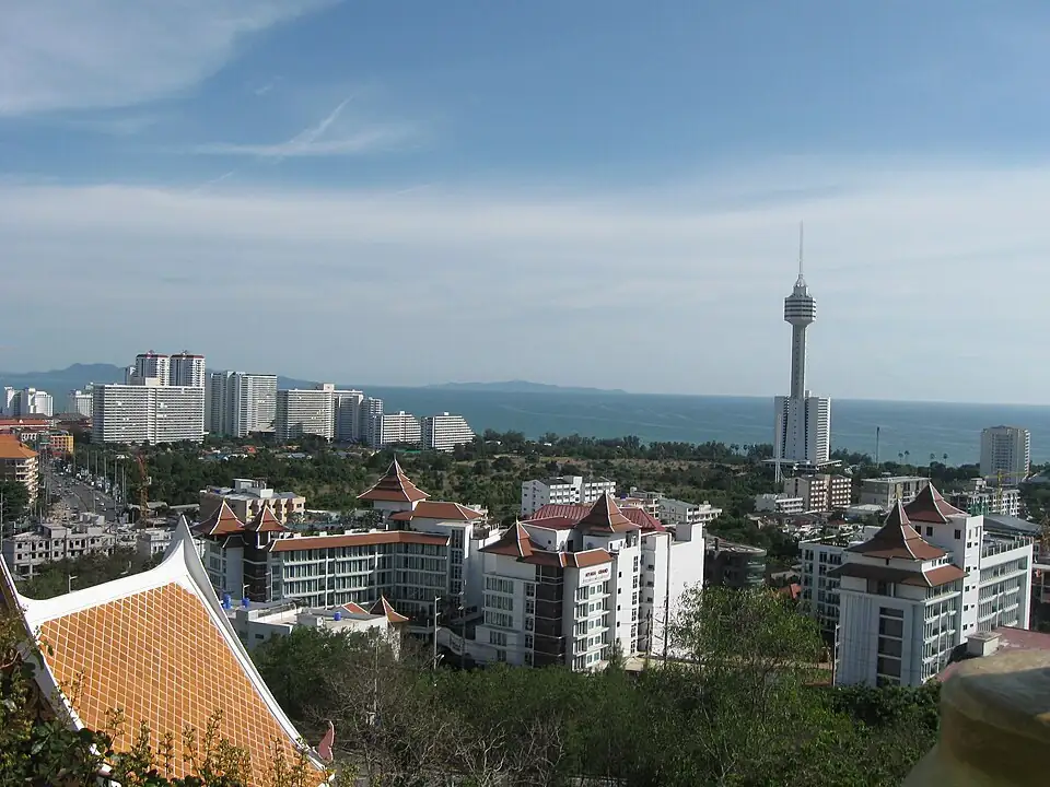 Rooftops and apartment blocks below Pratumnak Hill, a tall tower and the sea beyond