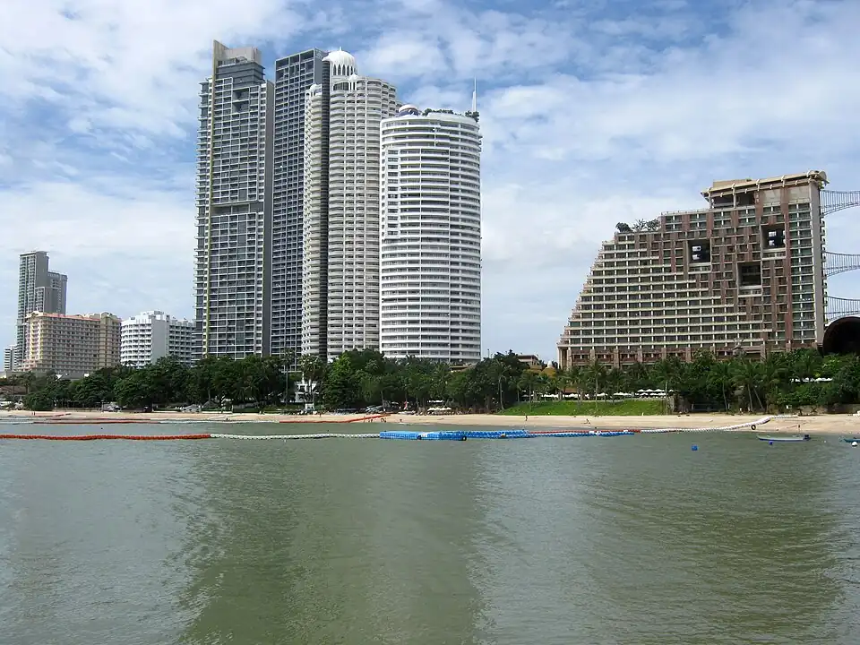 High-rise towers and a stepped hotel behind Wong Amat Beach at high water