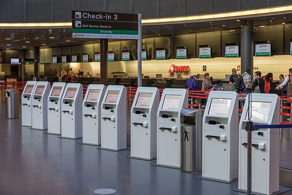 A row of self-service check-in machines in front of the counters at Zurich Airport